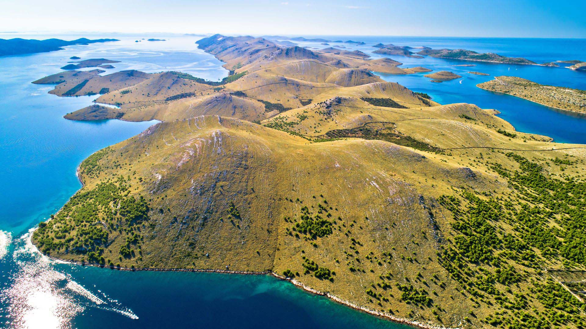 Kornati National Park Croatia — 89 uninhabited islands surrounded by deep blue Adriatic water, a private sailing yacht navigating between them — Sirena Collective