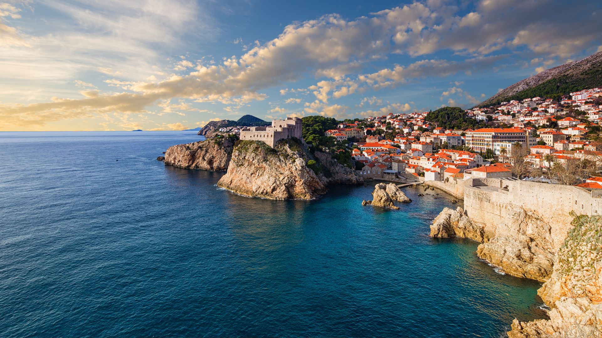 Bespoke luxury yacht anchored in a quiet Adriatic cove under a bright blue sky — high-performance corporate retreats in Europe