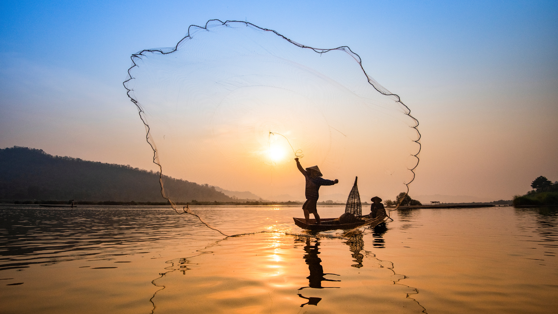 Fisherman casting net on the Mekong at sunrise — AMA Waterways Asia river cruise Vietnam Cambodia