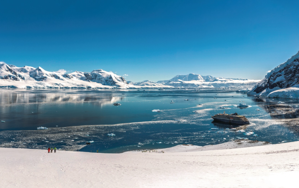Silversea luxury expedition ship and Zodiac excursion with penguins on Antarctic ice sheet