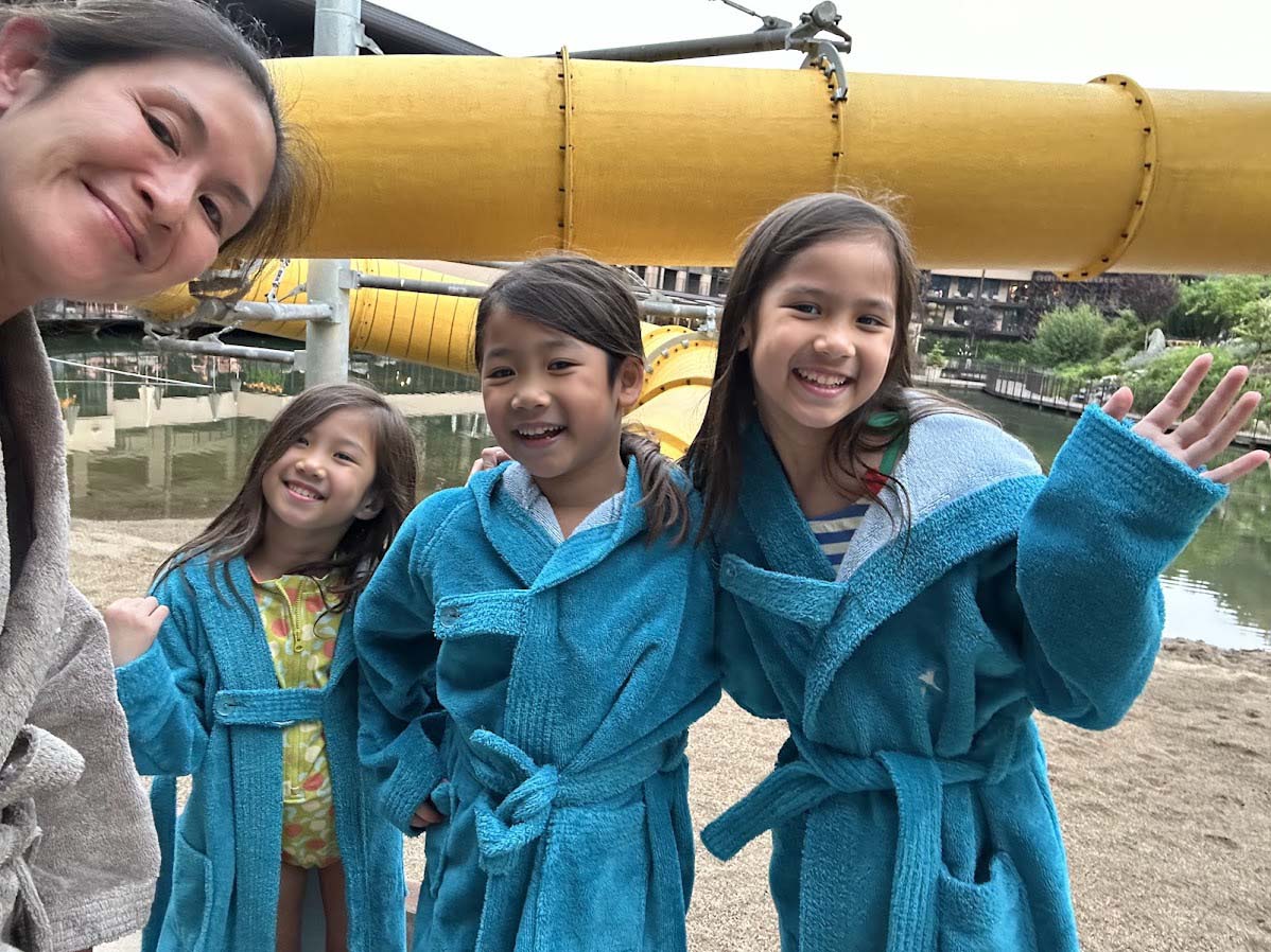 Kids in bathrobes in front of the water slide at Falkensteiner Family Resort Lido