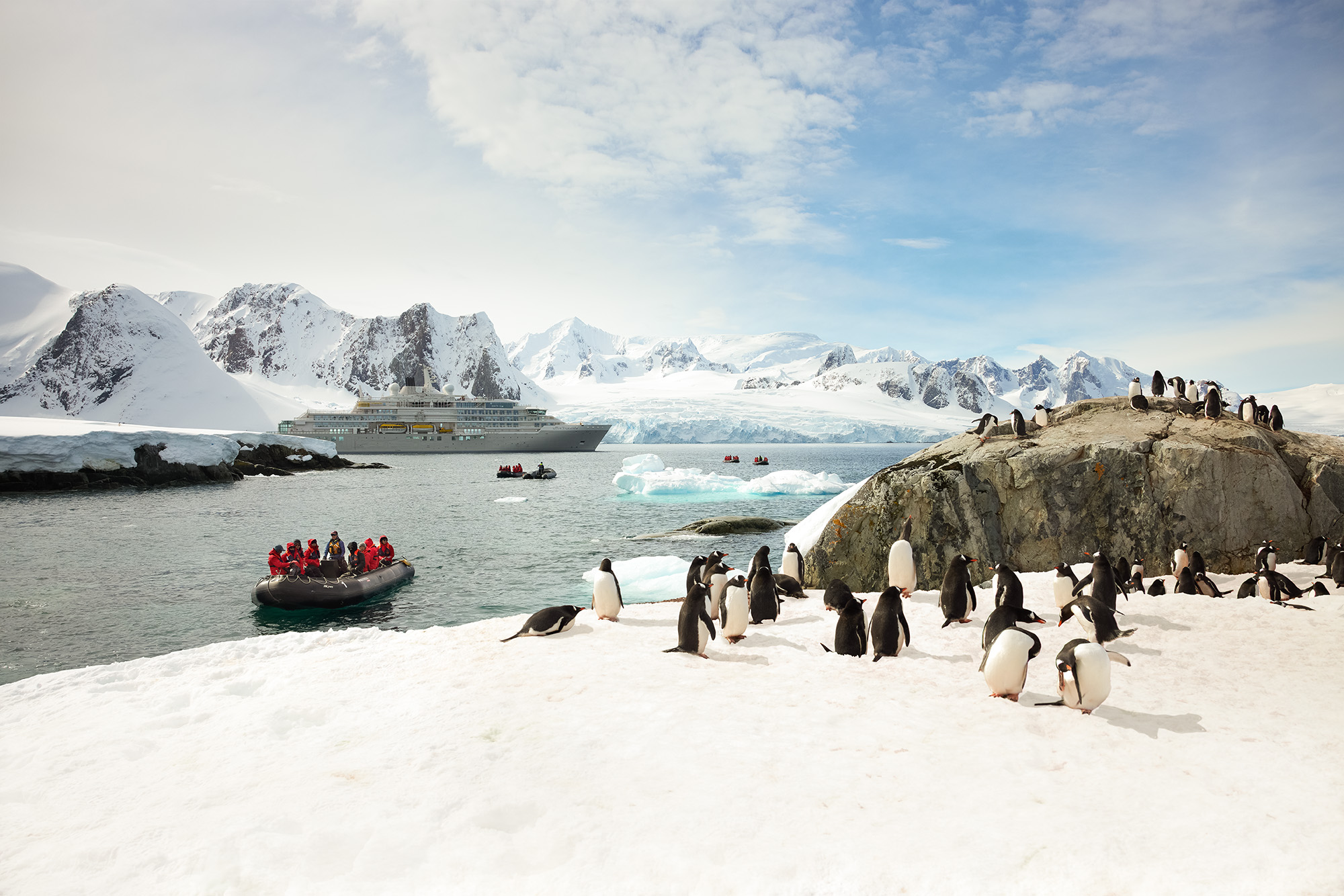 Silversea luxury expedition ship and Zodiac excursion with penguins on Antarctic ice sheet