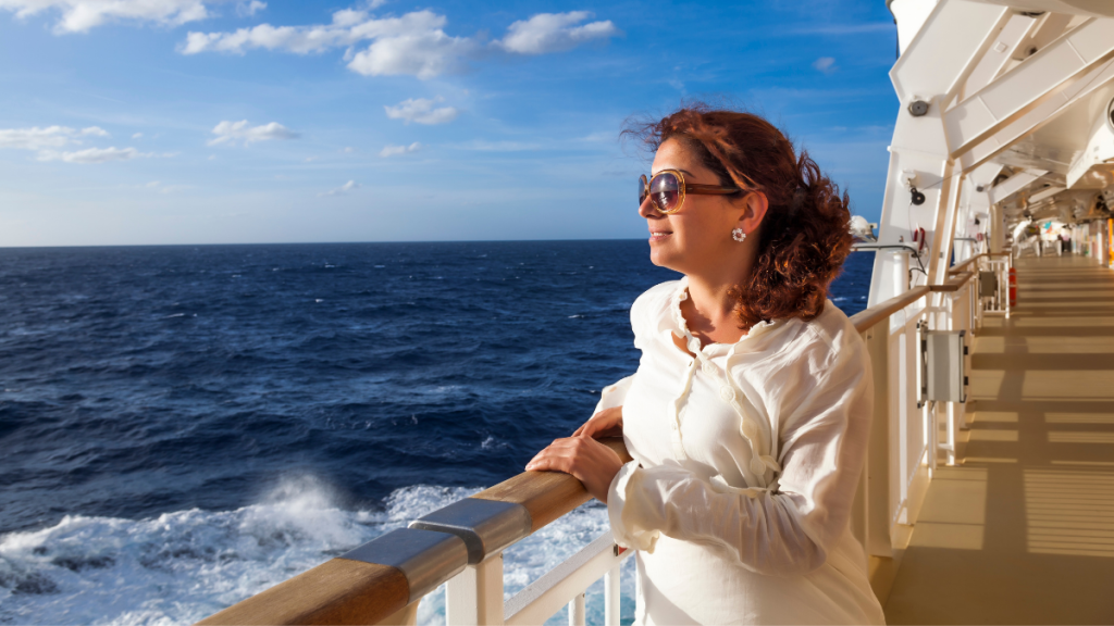 A woman enjoying the ocean view from a step-free, accessible deck on a luxury cruise ship.